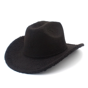 Close-up of dark brown western cowboy hat with plush wool-like texture and curved brim