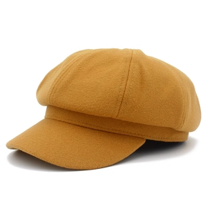 Coutures détaillées et texture laineuse sur une casquette gavroche moutarde