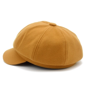 Gros plan détaillé d'une casquette gavroche jaune moutarde montrant les coutures fines