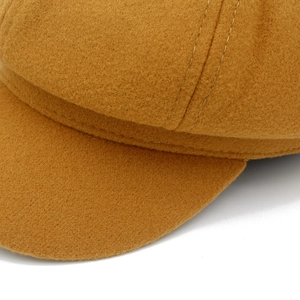 Gros plan détaillé de la casquette gavroche en laine jaune moutarde avec double couture
