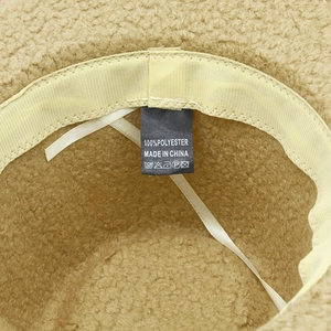 Detail of soft beige teddy fleece hat interior showing sweatband and washing label
