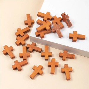 Dettaglio di vari pendenti a croce in legno naturale per la creazione di gioielli DIY