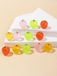 Détail de pendentifs pommes en résine facettée aux couleurs acidulées avec anneaux argent