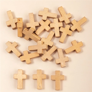 Dettaglio di piccoli ciondoli a croce in legno per gioielli fai da te color legno
