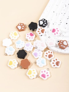 Macro detail of colorful resin cat paw charms and metal rings for DIY jewelry projects