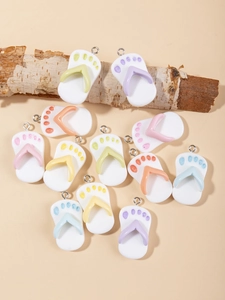 Vue à plat de breloques de tongs en résine couleurs macaron avec anneaux sur bois