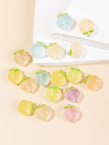 Détail macro de pendentifs pêche en résine pastel avec anneaux pour création bijoux DIY
