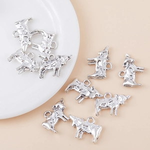 Vintage Silber Büffel Anhänger für DIY Schmuckherstellung auf weißem Keramikteller