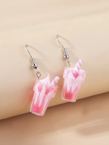 Detail of creative pink and white milkshake cup earrings with striped straw design