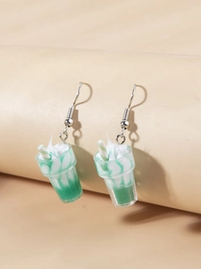 Close-up of creative 3D ice cream sundae earrings with green milkshake and straw detail