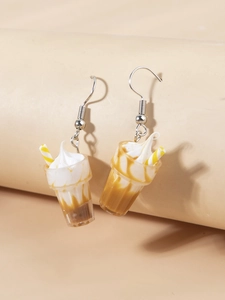 Detail of miniature ice cream sundae earring with cream topping and striped straw