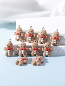 Close-up of DIY gingerbread man charms with red bows and silver loops for jewelry making