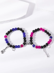 Detail of magnetic heart clasp connecting beaded bracelets with guitar and star charms