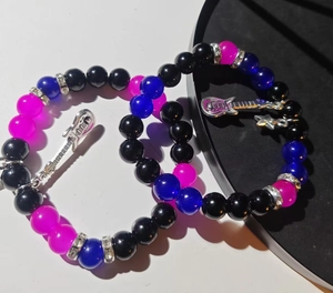 Detailed close-up of handmade beaded guitar bracelets with silver heart accents