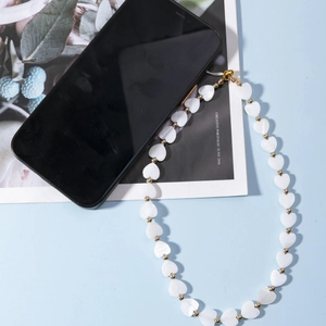 Dragonne de téléphone tendance avec perles de coquillage en cœur et détails dorés