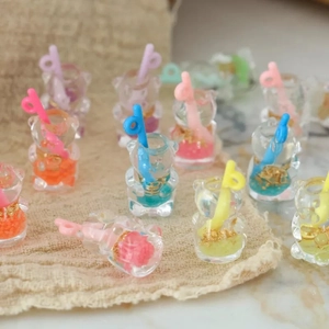Detailed close-up of mini resin bear straw cups with colorful foil for DIY jewelry