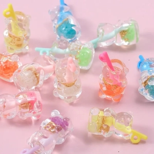 Close-up of colorful resin bear straw cup charms with glitter for DIY crafts and accessories