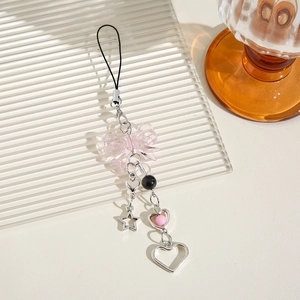 Schlüsselanhänger mit rosa Schleife Sternen und Perlen auf einem Glastablett