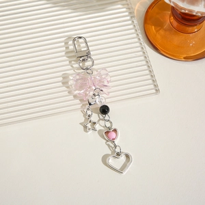 Schlüsselanhänger mit rosa Schleife und silbernem Stern auf minimalistischem Grund