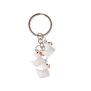 Minimalistische sleutelhanger met drie witte hars eendjes en een zilveren metalen ring