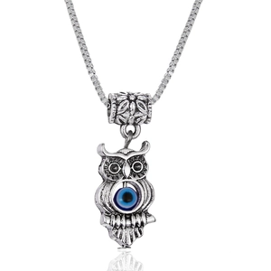 Macro view of vintage owl pendant with blue evil eye detail on a silver box chain