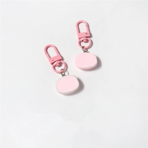 Close-up of pink resin cartoon pig keychain with a matching metallic lobster clasp