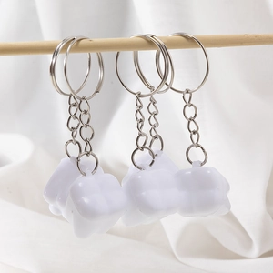 Set of four creative tooth-shaped keychains with white molar charms on silver rings