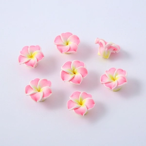 Makroaufnahme von rosa-gelben Plumeria-Blütenperlen aus Ton für die Schmuckherstellung