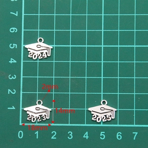 Macro view of silver graduation cap charms featuring years 2023, 2024, and 2025