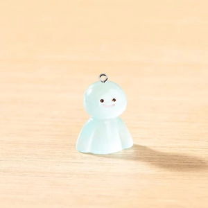 Détail d'un pendentif fantôme bleu translucide avec anneau sur fond de bois