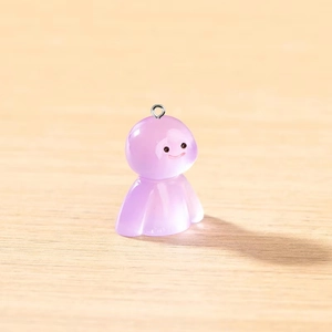 Détail macro d'un pendentif fantôme en résine violette avec un visage souriant
