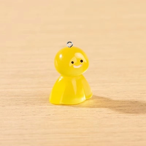 Détail d'un pendentif fantôme en résine jaune brillant avec un petit anneau en métal