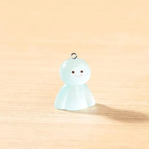 Gros plan d'un pendentif Teru Teru Bozu vert menthe translucide avec anneau argenté