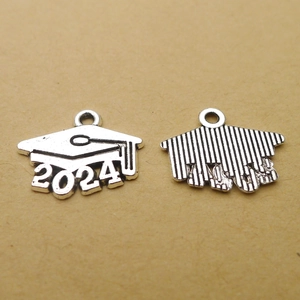Macro shot of 2024 graduation charms in antique silver with mortarboard detail