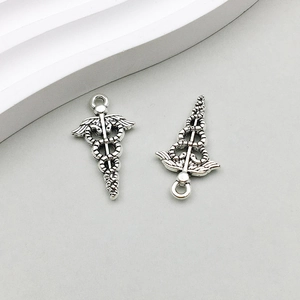Dettaglio dei ciondoli caduceo in argento vintage con ali per gioielli fai-da-te
