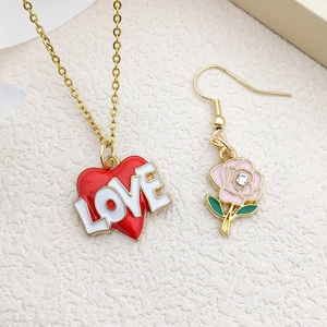 Vue détaillée d'un ensemble bijoux collier cœur LOVE rouge et boucle d'oreille rose