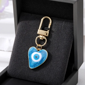 Détail macro du porte-clés œil protecteur en cœur avec résine bleue et fermoir doré