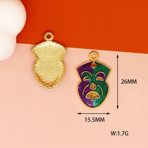 Detail of colorful mask pendant showing 26mm height and textured gold alloy back