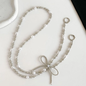 Crossbody pearl bead phone strap with silver bow accent and metal ring fasteners