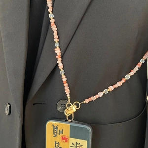 Détail d'une lanière de téléphone en cristal rose et perles d'eau douce avec fermoir doré