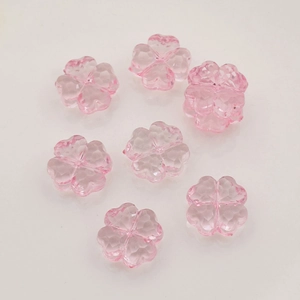 Detail of pink transparent acrylic four-leaf clover beads with multi-faceted cut finish
