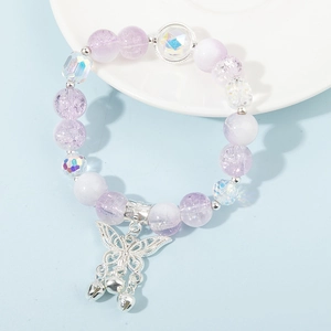 Nahaufnahme von lila Kristall-Armband mit Schmetterlings-Anhänger und kleinen Silberglocken