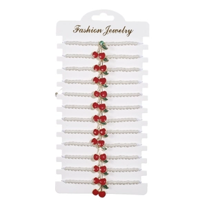Set di 12 braccialetti di perle bianche con ciondoli a ciliegia rossa su carta