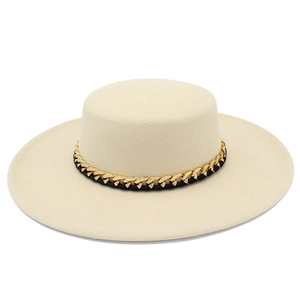 Dettaglio di un cappello boater beige con catena dorata e finiture in tessuto nero