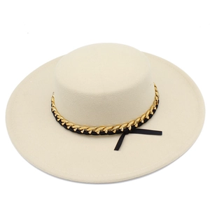 Dettaglio cappello in feltro crema con catena dorata e fiocco in nastro nero