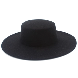 Detail view of the matte wool felt texture on a vintage 10cm wide brim black flat top hat