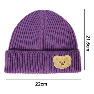 Detail of purple ribbed knit beanie featuring a cute beige plush bear patch and 22cm width