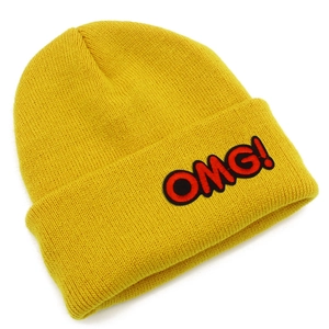 Detailed view of yellow knitted beanie with red OMG! embroidery and thick texture