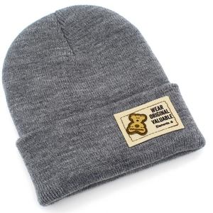 Gros plan sur le bonnet en tricot gris avec texture côtelée et écusson en tissu d'ours
