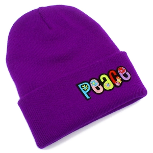Detail of multi-colored PEACE embroidery and floral pattern on purple knit beanie